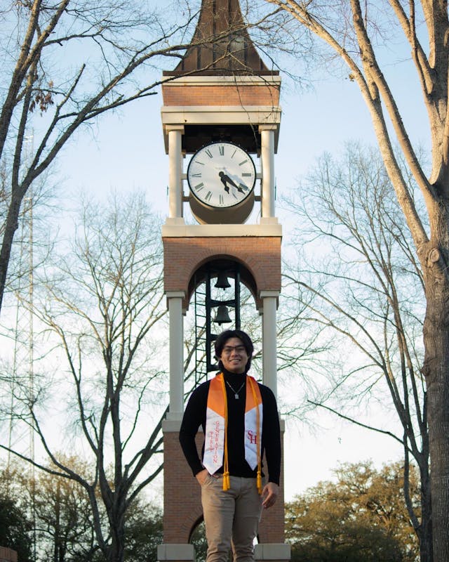 Graduation picture standing in front of SHSU clock tower